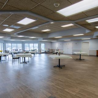 A spacious and modern event space featuring tables and ample natural light.