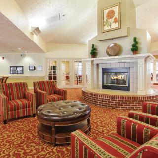 A cozy living room with a fireplace and striped seating, arranged in a welcoming atmosphere.