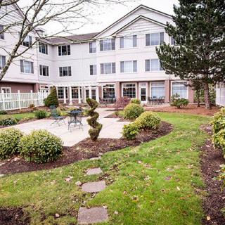 A well-maintained garden with a pathway leading to a multi-story residential building.