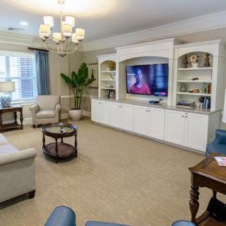 A cozy living room with a large TV, comfortable seating, and elegant decor.