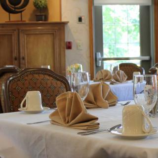 A neatly set dining table with folded napkins and cups in a restaurant setting.
