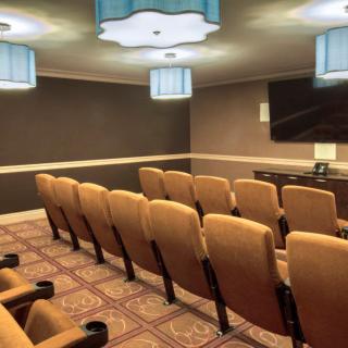 A small theater room with rows of seats and a screen at the front.