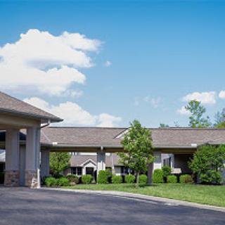 A view of a motel with well-maintained landscaping under a clear blue sky.