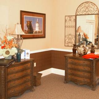 A stylishly decorated corner featuring elegant furniture, a mirror, and decorative elements.