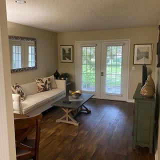 A cozy living room with a sofa, coffee table, and decorative elements in a well-lit space.