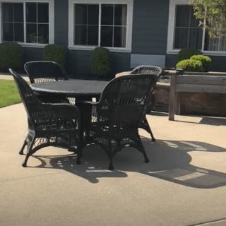 A sunny patio with wicker furniture set around a table.