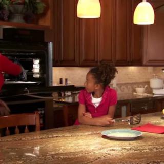 Family scene in a home kitchen, with cooking in progress.