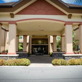 The main entrance of a hotel with columns and landscaped surroundings.