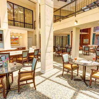 A bright and cozy indoor cafe with tables and chairs arranged neatly under natural daylight.