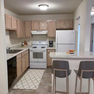A modern kitchen featuring essential appliances and a cozy dining area.