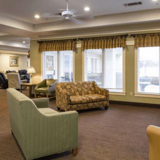 A cozy living room with various sofas, large windows, and ambient lighting.