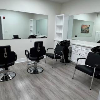 A modern hair salon with stylish black chairs and large mirrors.