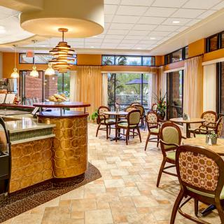 A cozy cafe interior featuring tables and chairs with warm lighting.