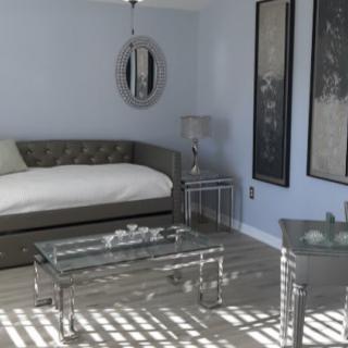 A modern bedroom featuring a daybed, glass table, and contemporary artwork on the walls.