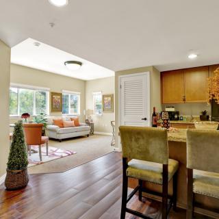 A spacious living area featuring an open floor plan with hardwood floors, modern furnishings, and abundant natural light.