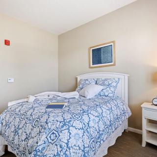 A cozy bedroom with a patterned bedspread and a nightstand with a lamp.
