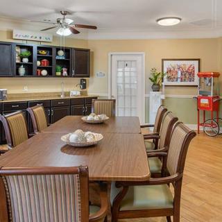 A cozy dining area with a wooden table, comfortable chairs, and a popcorn machine.