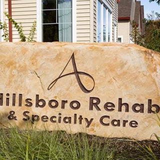 Entrance sign for Hillsboro Rehab & Specialty Care with building in the background.
