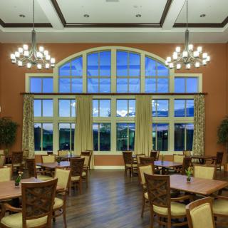 An elegantly designed dining room with large windows and chandeliers.