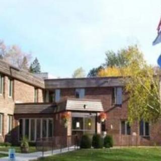A brick residential building surrounded by trees.