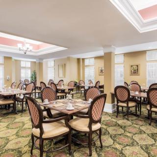 An elegantly designed dining room with multiple tables and chairs arranged neatly.