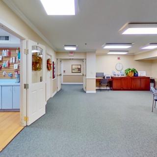 A spacious lobby area with a carpeted floor, reception desk, and decoration.