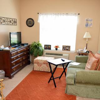 A cozy living room with a sofa, television, and various decorations.