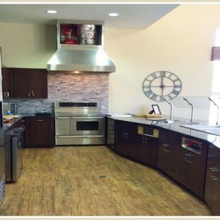 A modern kitchen with sleek cabinetry, stainless steel appliances, and wood flooring.