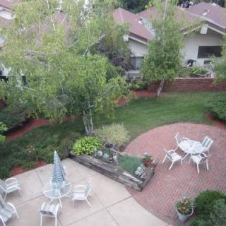 A peaceful backyard patio area with outdoor seating and lush greenery.