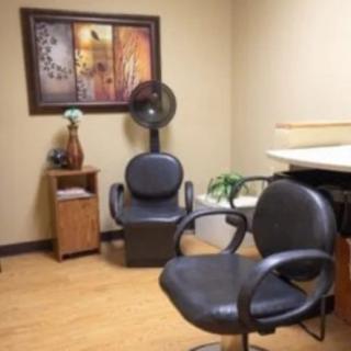 A cozy hair salon interior with chairs and wall art.