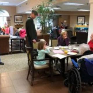 A family visits and interacts with residents in a nursing home.