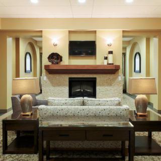 A modern living room with a central fireplace, featuring a cozy sofa and warm lighting.