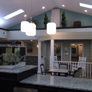 A modern interior featuring a spacious open kitchen and living area with stylish lighting and an aquarium.
