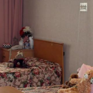 A cozy child's bedroom with floral bedspreads and stuffed toys.