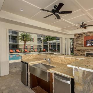 A luxurious outdoor kitchen and entertainment area next to a pool.
