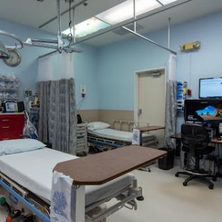 A view of an emergency room with patient beds and medical equipment.