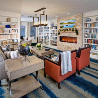Cozy living room with bookshelves, a fireplace, and comfortable seating.