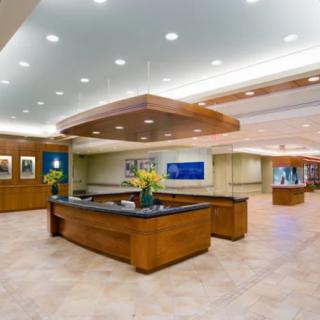 A modern office lobby with a central reception desk and stylish lighting.