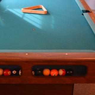 A pool table with a triangular rack placed on it, ready for a game.