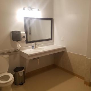 A clean and well-lit bathroom with a large mirror above the sink.