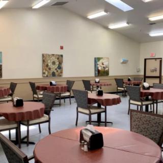 A cozy dining room with neatly arranged tables and chairs, adorned with decorative wall art.