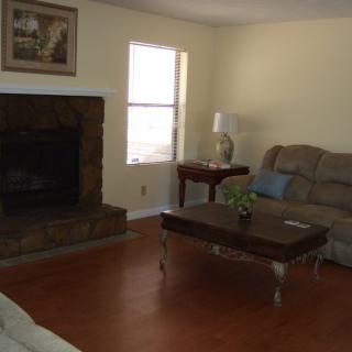 A cozy living room with a fireplace, sofa, and wooden coffee table.