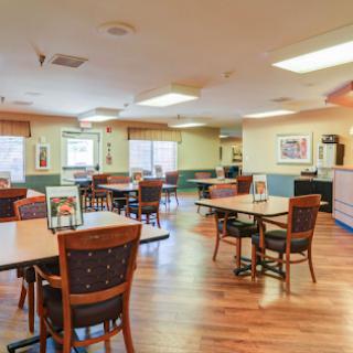 A cozy dining area featuring wooden tables and chairs, designed for a communal atmosphere.