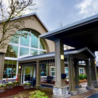 A modern building entrance with large glass windows and a covered entryway.