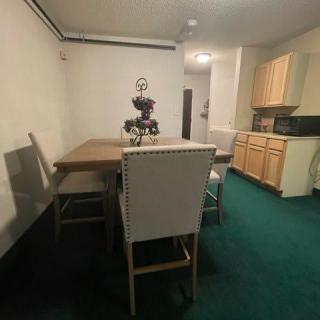 A cozy dining area with a table and chairs next to a compact kitchen setup.