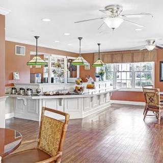 A spacious, modern kitchen with an open dining area featuring pendant lights and hardwood flooring.