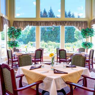 A bright and inviting restaurant dining area with well-arranged tables and large windows.