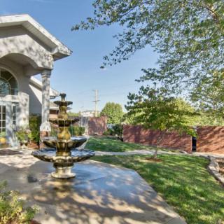 A beautifully landscaped garden with a multi-tiered fountain and lush greenery.