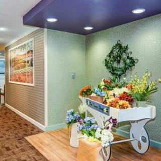 A beautifully decorated hallway with a floral cart and wreath.