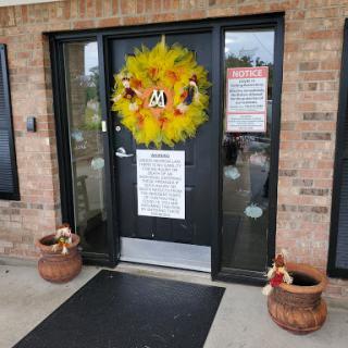 A festive entrance adorned with a colorful fall wreath and potted plants.
